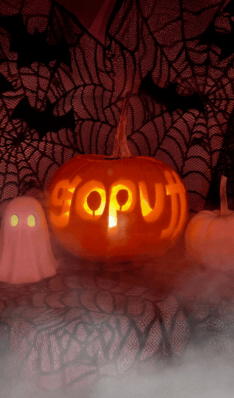 Gopuff Halloween scene: carved pumpkin, ghost, spiderwebs, bats, and fog.