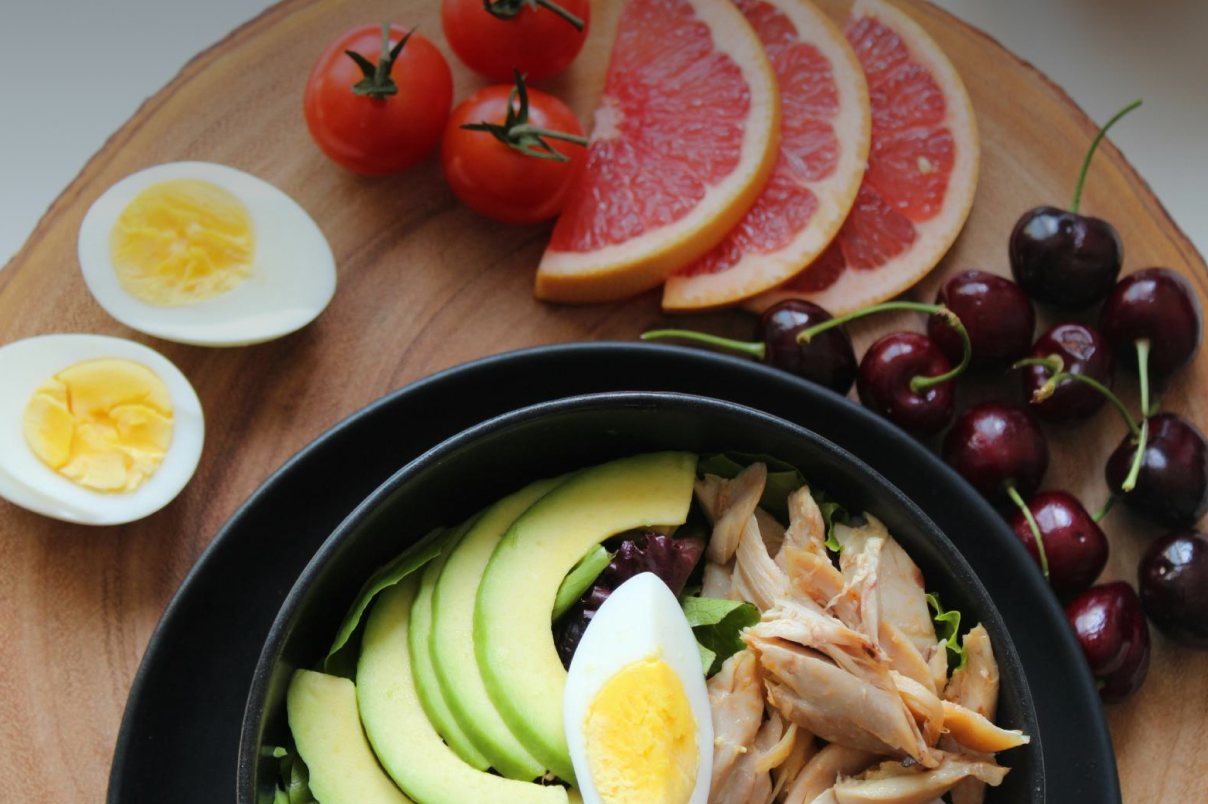 Platter of raw salmon on a table with other fresh foods.