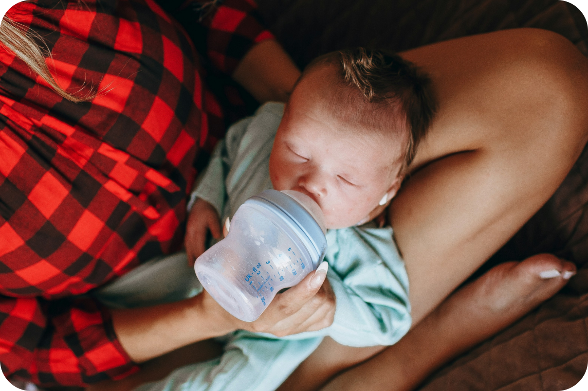 Woman Feeding her baby from a bottle in her lap