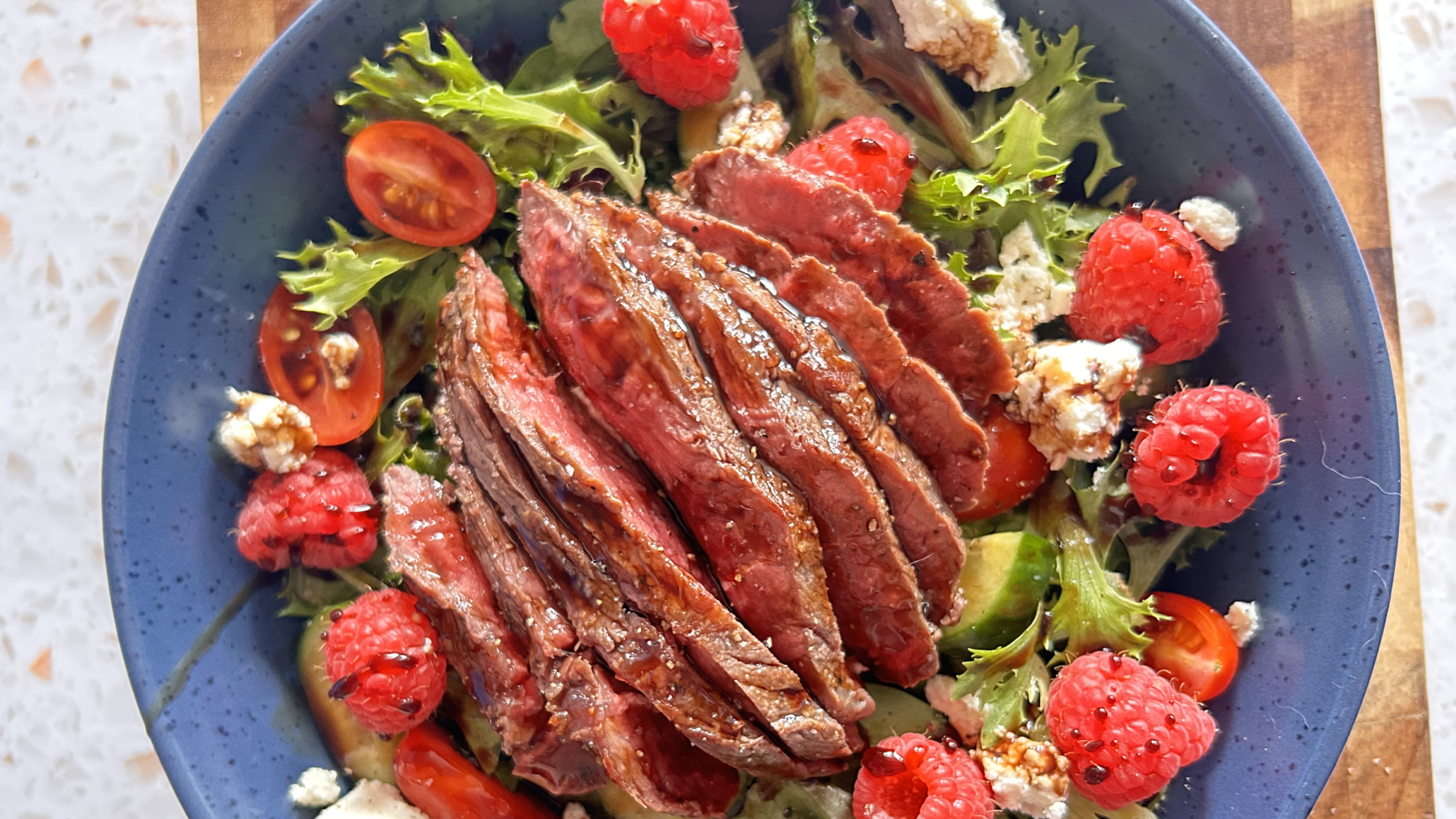 Gopuff steak salad with greens, raspberries, tomatoes, feta, and balsamic glaze.