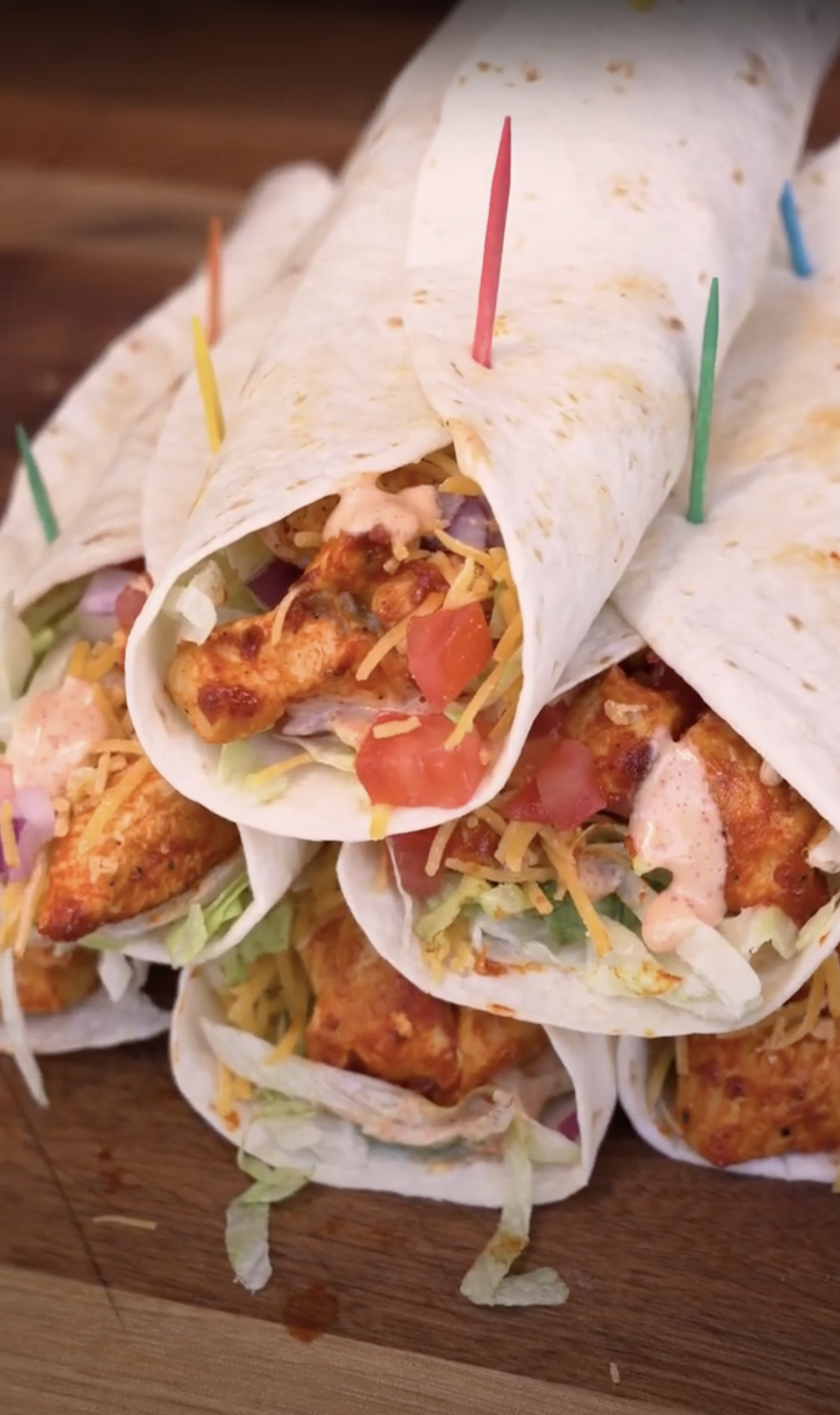 Gopuff chicken wraps with lettuce, cheese, tomato, onion, and sauce, held by toothpicks.