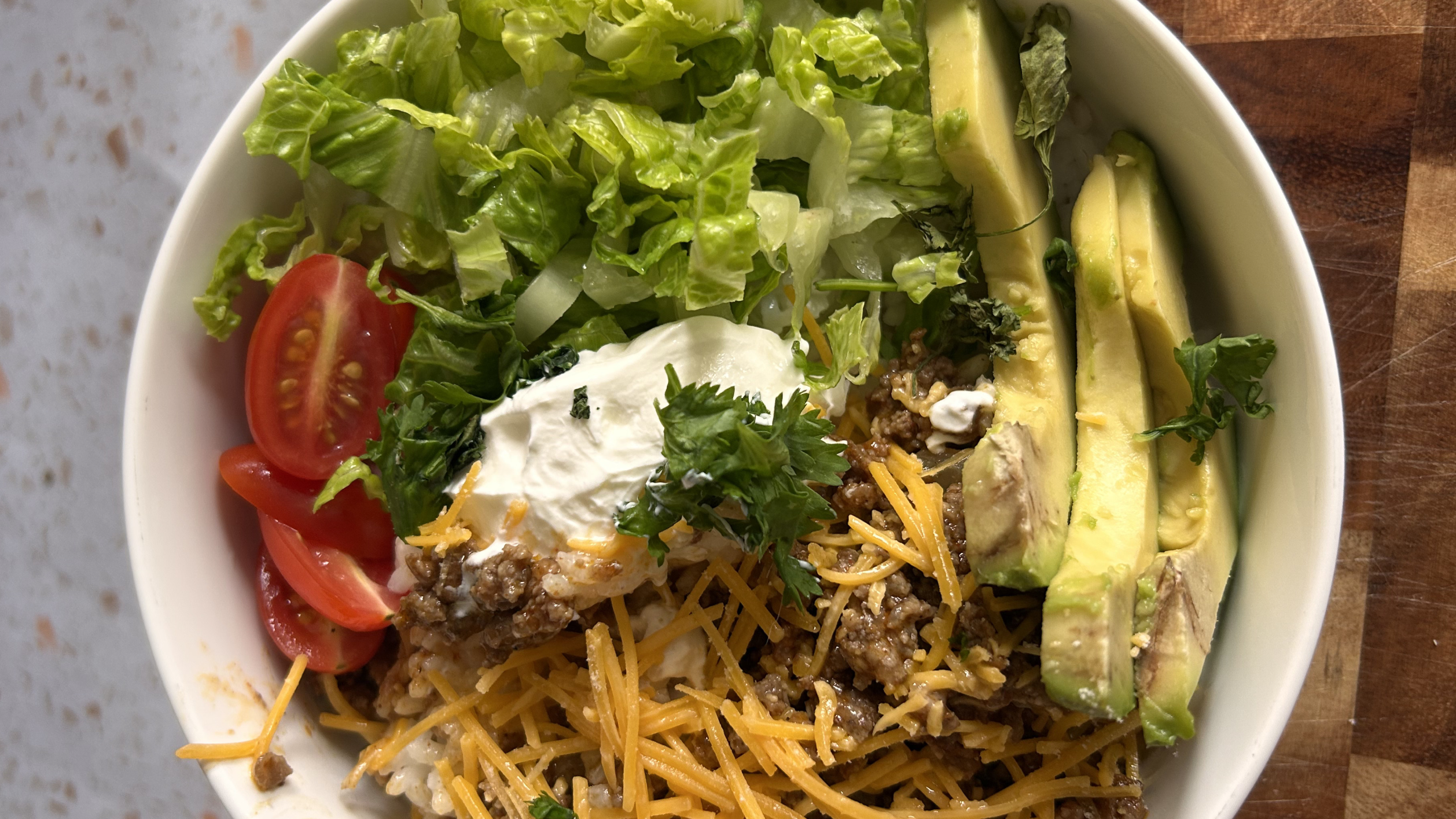 Gopuff taco bowl: seasoned ground beef, rice, shredded cheese, lettuce, tomatoes, sour cream, avocado.
