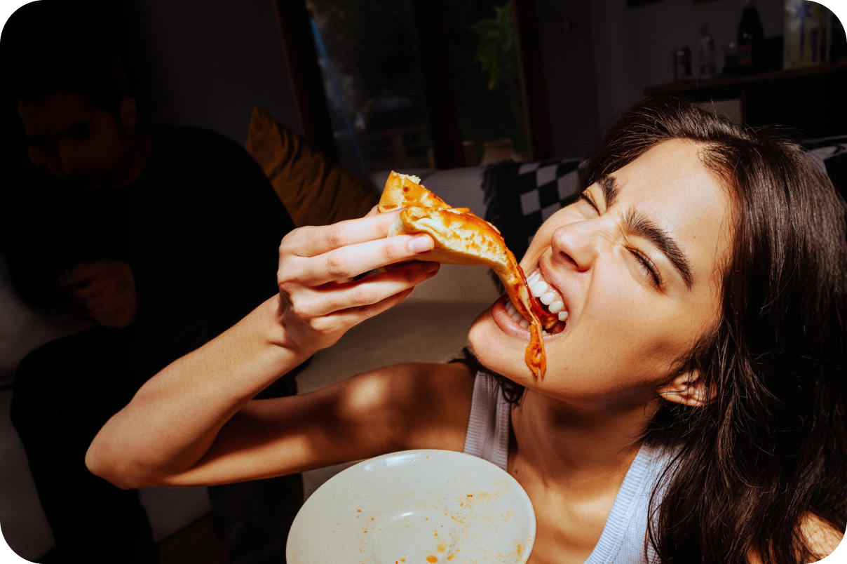 Woman eating pizza with cheese dripping off the slice