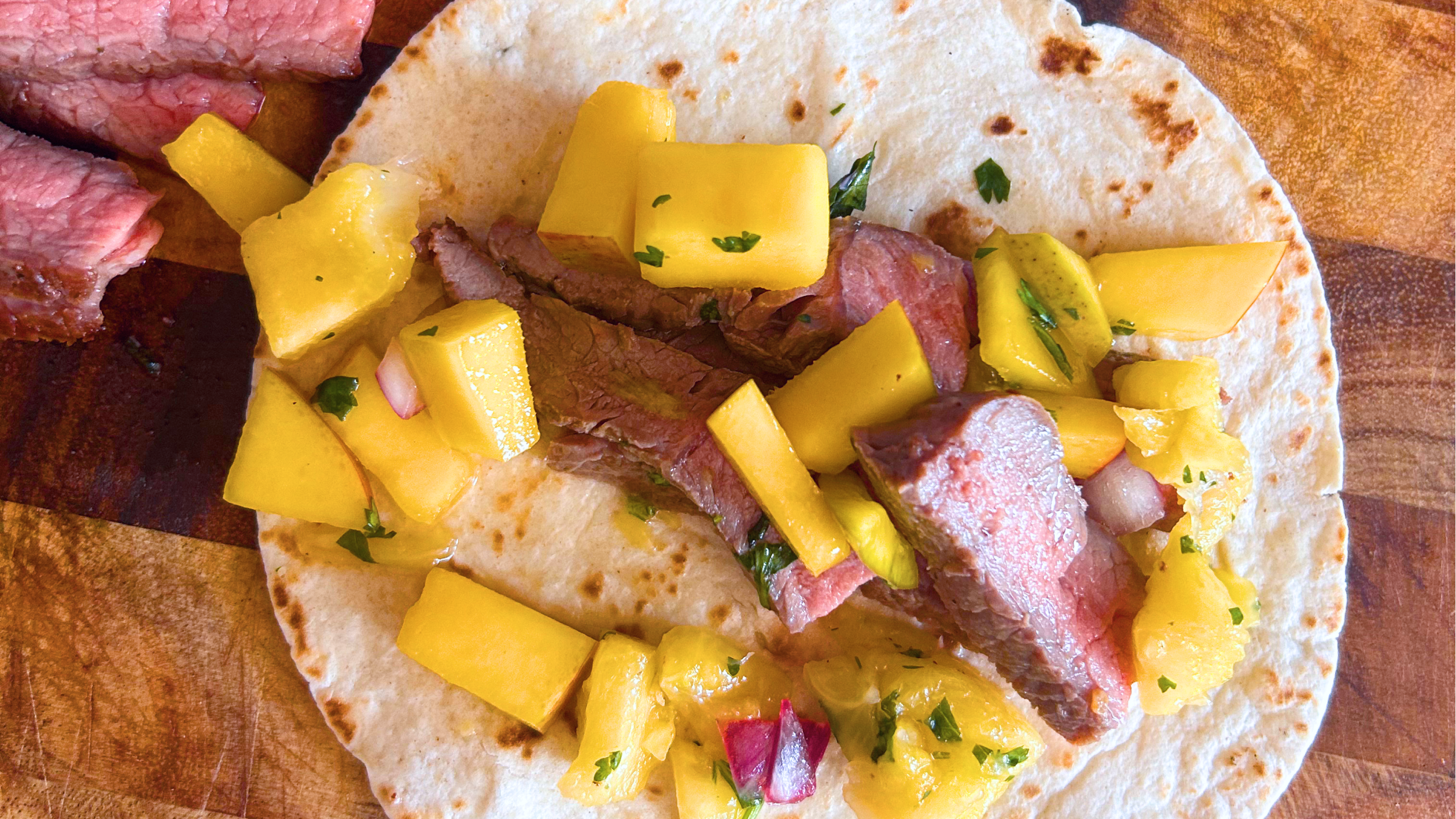 Gopuff steak taco with fresh mango salsa and herbs.